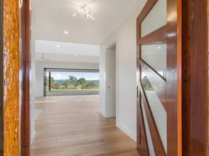 Timber-floored hallway opening to the view, Sutton renovation